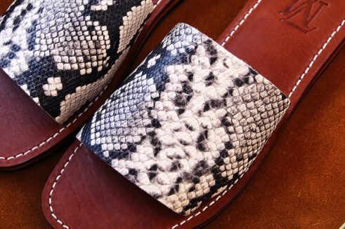 Moroccan handmade slide sandals with a black-and-white python print leather upper and a sculpted black rubber sole