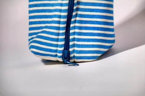Blue and white striped cosmetic pouch with a zipper closure and a small handle.