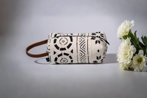 A black and white Moroccan-inspired geometric pouch with a leather handle, perfect for storing essentials in style.