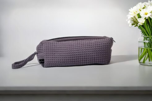 Gray textured pouch with handle and zipper closure, perfect for organizing cosmetics and small items.