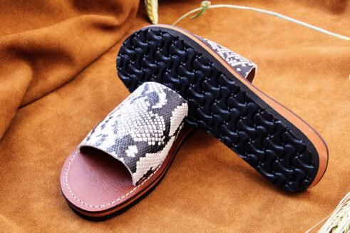 Moroccan handmade slide sandals with a black-and-white python print leather upper and a sculpted black rubber sole