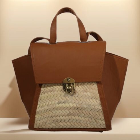 A stylish, handcrafted leather and woven material backpack with a brass clasp, set against a neutral background with a modern and elegant feel.