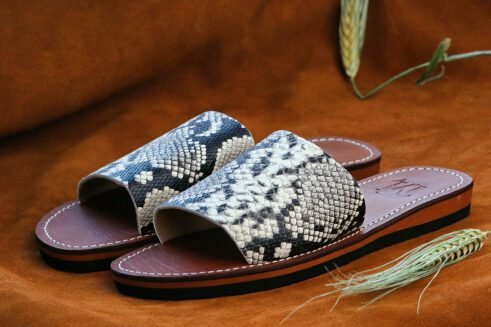Moroccan handmade slide sandals with a black-and-white python print leather upper and a sculpted black rubber sole