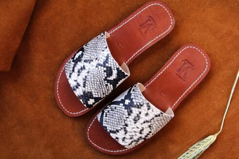 Moroccan handmade slide sandals with a black-and-white python print leather upper and a sculpted black rubber sole