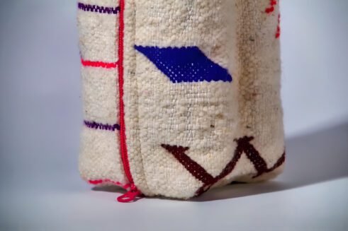 Moroccan-inspired pouch with a colorful pink and purple zig-zag design, featuring a handle and secure zipper closure.