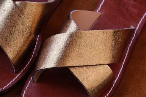 Elegant handmade golden leather sandals with a criss-cross design and a touch of Moroccan artistry