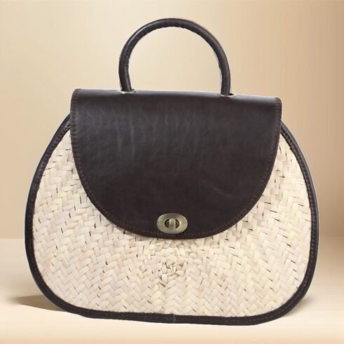 Classic handbag featuring a dark brown leather top and woven cane body, with a rounded silhouette and brass clasp closure, set against a neutral beige background.