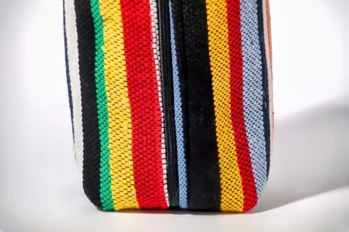 Colorful striped cosmetic pouch with handle, perfect for organizing your beauty essentials.
