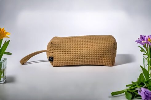 Beige textured pouch with a leather handle, perfect for organizing small essentials with a practical and stylish design.
