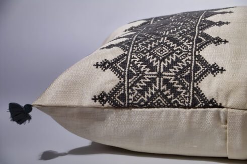 Gray Moroccan pillow with black embroidered geometric design and tassels