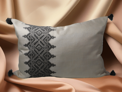 Gray Moroccan pillow with black embroidered geometric design and tassels