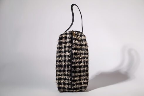 Black and white textured pouch with handle and zipper closure, perfect for organizing cosmetics and small essentials.