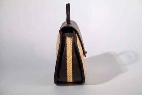 Classic handbag featuring a dark brown leather top and woven cane body, with a rounded silhouette and brass clasp closure, set against a neutral beige background.