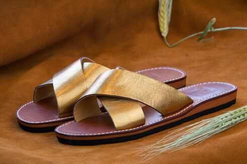 Elegant handmade golden leather sandals with a criss-cross design and a touch of Moroccan artistry