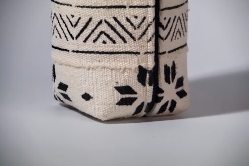 A black and white Moroccan-inspired geometric pouch with a leather handle, perfect for storing essentials in style.