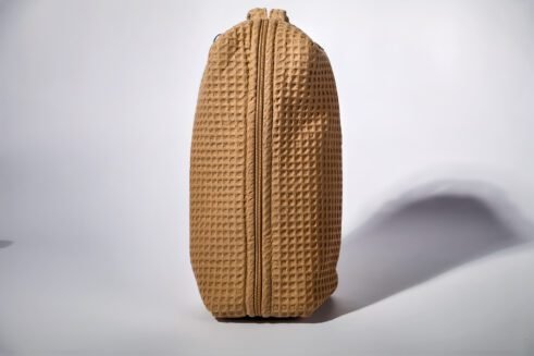 Beige textured pouch with a leather handle, perfect for organizing small essentials with a practical and stylish design.